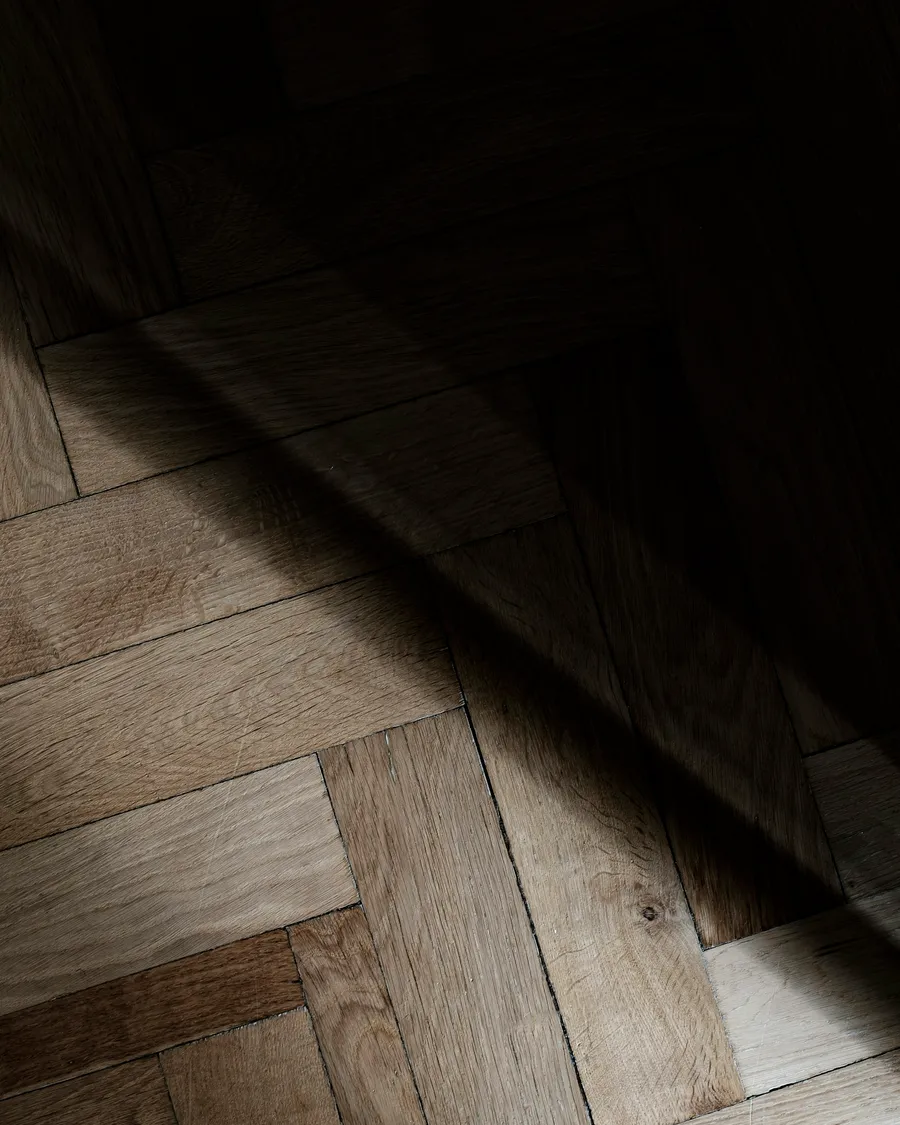 Parquet ancien vitrifié, lames sombres et reflet