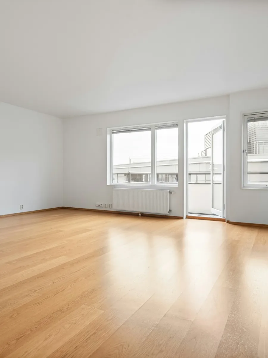 Séjour aux murs blancs et au parquet clair, grandes fenêtres